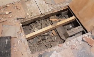 Asbestos-containing debris identified within floor voids before specialist asbestos removal in Central London.